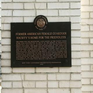 A historical plaque marking the site of the Former American Female Guardian Society's Home for the Helpless.