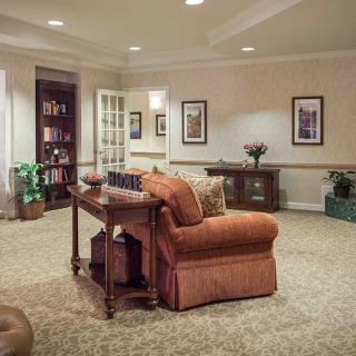 A cozy living room with a comfortable sofa, coffee table, and bookshelf.