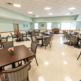 An empty dining room with neatly arranged tables and chairs.