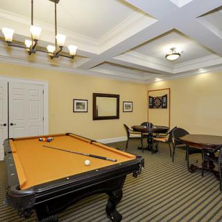 A well-lit game room featuring a pool table and seating area.