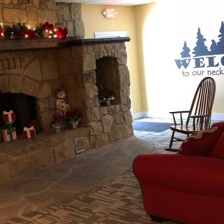 Cozy living room with a stone fireplace, adorned with holiday decorations and a welcoming atmosphere.