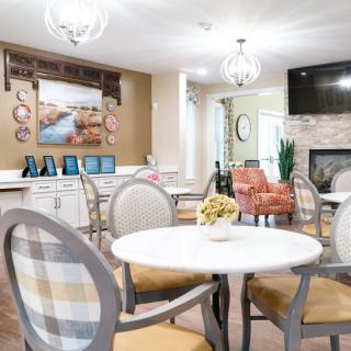 A bright and modern living area with a dining table, stylish chairs, and decorative elements.
