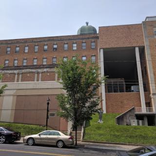 A brick building with a dome structure, seen from the street.