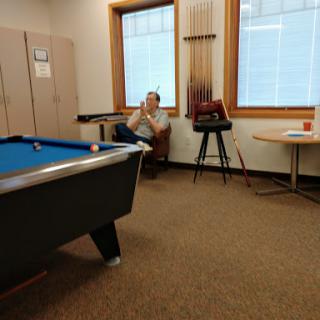 A quiet moment in a recreational room featuring a pool table and a person relaxing.