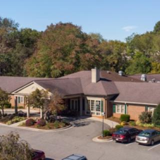 A charming residential building surrounded by vibrant autumn foliage.