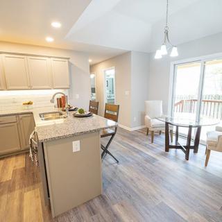 A modern kitchen and dining area with an open layout, featuring ample natural light and contemporary design elements.