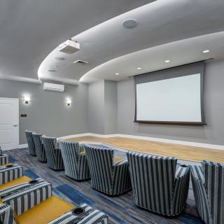 A modern home theater with striped seating and a large projector screen.