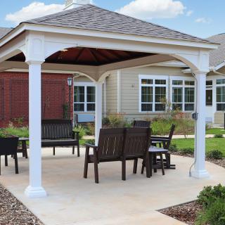 A scenic backyard gazebo with seating area and patio.