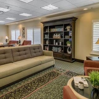 A well-decorated living room with a sofa, bookshelf, and carpet.