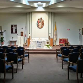 A serene interior view of a chapel, featuring an altar and seating arrangements.