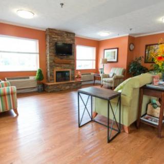 A cozy living room with a fireplace, comfortable seating, and warm decor.