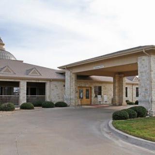 A stone building with a covered entrance and attached driveway.