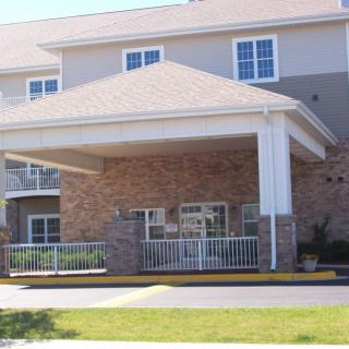 A residential building with a covered entrance and brick facade.