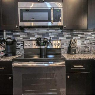 A modern kitchen setup featuring a microwave and oven with a stylish backsplash.