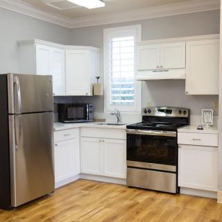 A modern kitchen with stainless steel appliances and white cabinets.