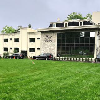 A contemporary building surrounded by lush green grass.