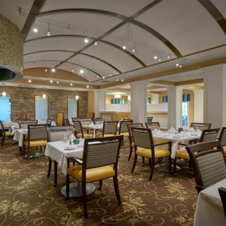 An elegantly designed restaurant interior with neatly arranged tables and chairs, featuring stylish lighting and decor.