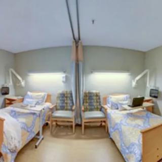 A hospital room with two beds and medical equipment.