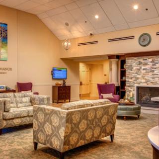 A cozy lounge area featuring comfortable seating and a stone fireplace, perfect for relaxation.