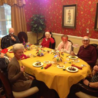 A group of seniors enjoying a meal together at a beautifully decorated table.