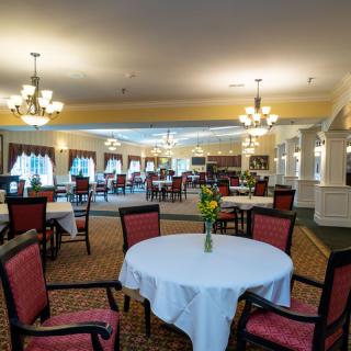 A spacious dining area with elegant lighting and neatly arranged tables.