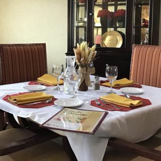 A beautifully set dining table in a restaurant, complete with napkins, glasses, and cutlery.