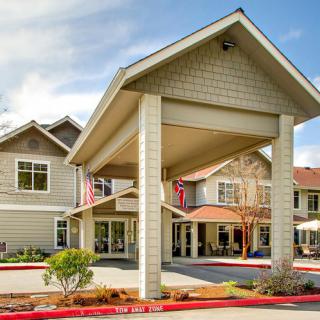 The front entrance of a modern building with large columns and a covered entryway.