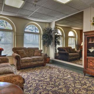 A cozy living room with sofas, a large mirror, and a television cabinet.