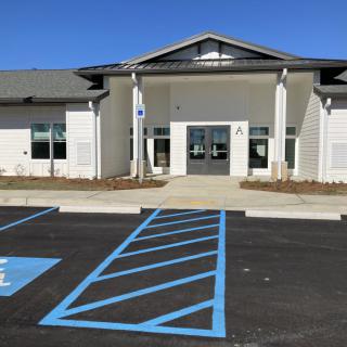 A modern building with a parking lot featuring marked handicap spaces.