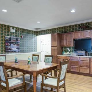 A cozy dining area with wooden furniture and cabinetry, featuring a table set for four.