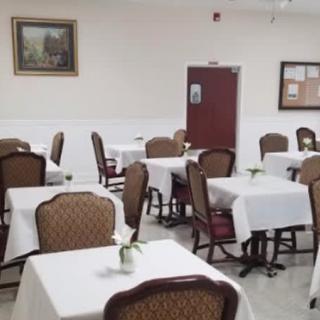 An empty dining room with tables and chairs neatly arranged.