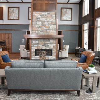 A modern living room with a central fireplace, surrounded by comfortable seating and elegant decor.