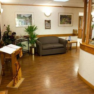 A cozy waiting room with a sofa and plants, designed for comfort.