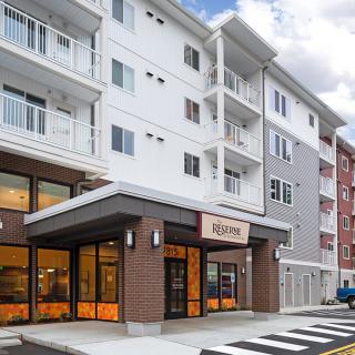 A modern multi-story building featuring a commercial storefront at street level.
