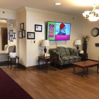 A cozy lobby area with a sofa, television, and various decorations.