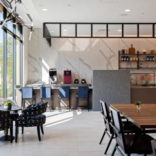 A modern cafe interior with natural light, featuring various seating options.