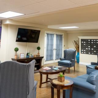 A cozy living room with comfortable seating and a wall-mounted TV.