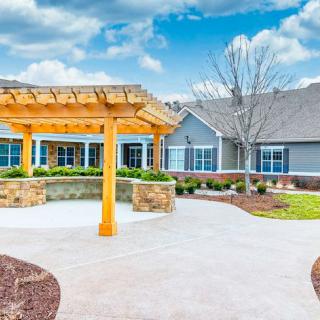 A modern house with landscaped garden and wooden pergola.