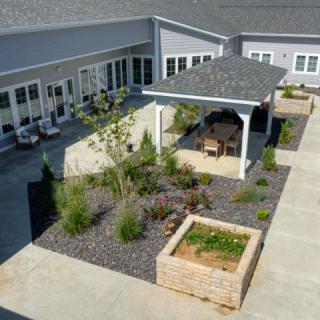 A landscaped courtyard with a pergola and raised garden beds.
