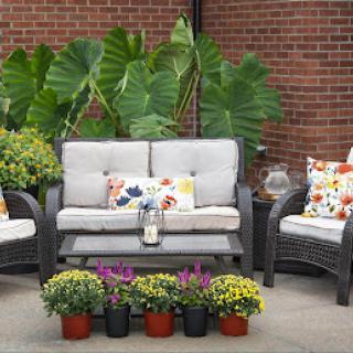 A cozy outdoor seating area adorned with vibrant cushions and blooming flowers.