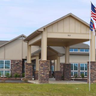 A modern building with a prominent entrance and a flagpole in front.