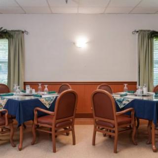 A neatly arranged dining room with tables and chairs, ready for guests.