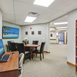 A modern office meeting area with a conference table and computer desk.