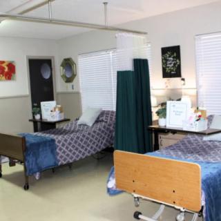 A hospital room with two patient beds separated by a curtain.