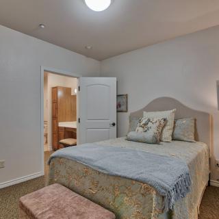 A cozy bedroom with a neatly arranged bed, soft lighting, and subtle decor.