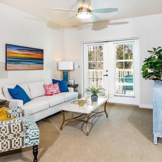 A modern living room featuring stylish furniture, colorful artwork, and a ceiling fan for a cozy atmosphere.