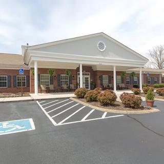 A building with a front entrance and attached parking lot featuring accessible parking spaces.