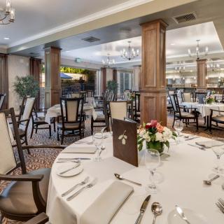 An elegantly set dining room in a restaurant with neatly arranged tables and decor.
