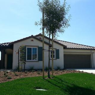 A suburban house with a well-maintained front yard and attached garage.