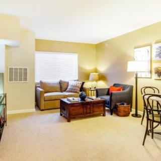 A cozy living room with a sofa, coffee table, and ambient lighting.